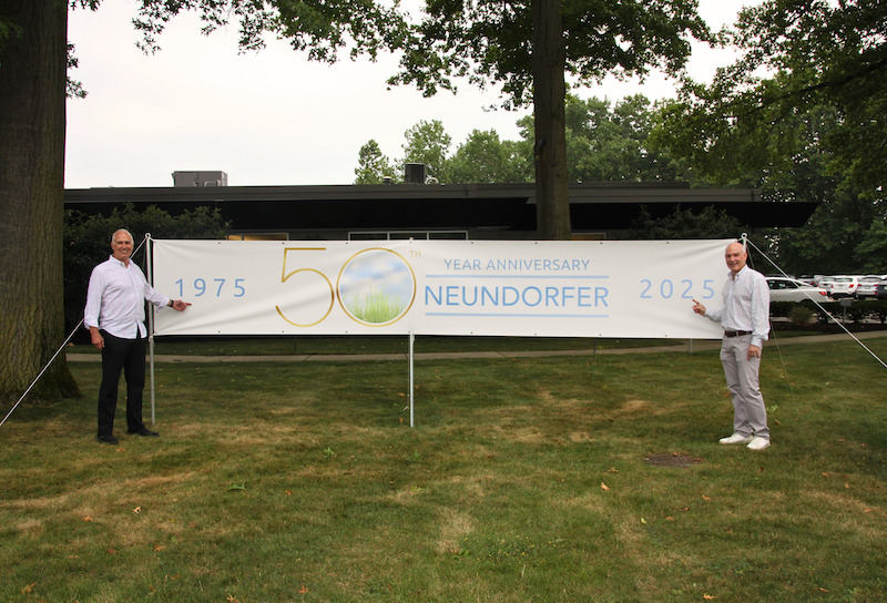 Neundorfer founder and current CEO holding 50th anniversary banner at company headquarters in Willoughby, Ohio during 2025 anniversary celebration